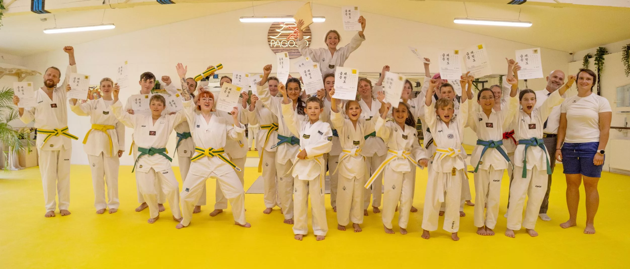 Kinder und Erwachsene feiern gemeinsam ihre Taekwondo-Gürtelprüfung