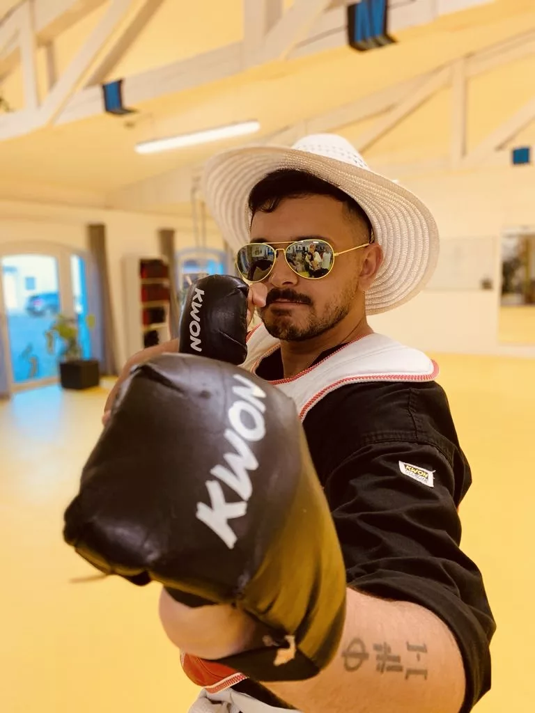 Boxer mit Handschuhen, Sonnenbrille und weißem Hut beim Fitnessboxen im PAGOJO